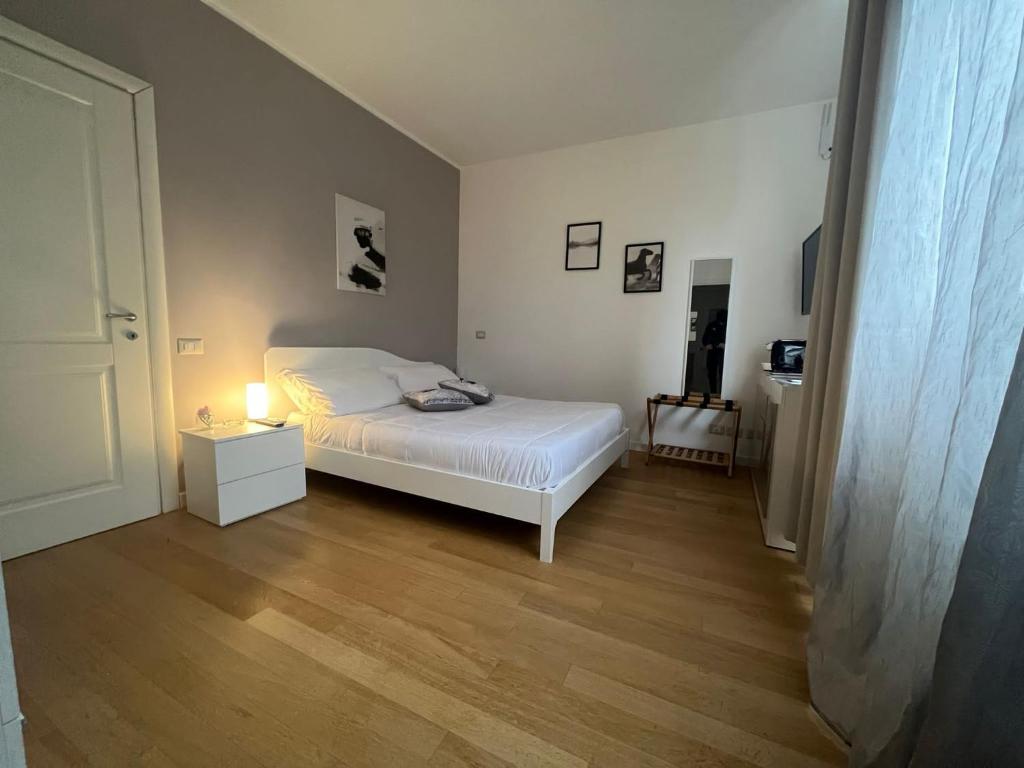 ein Schlafzimmer mit einem Bett und einer Lampe auf einem Holzboden in der Unterkunft Horizon Suites in Cefalú
