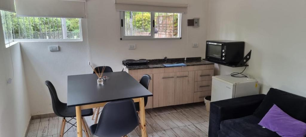 una pequeña sala de estar con mesa y TV. en Departamento Costa Paz en Villa Carlos Paz