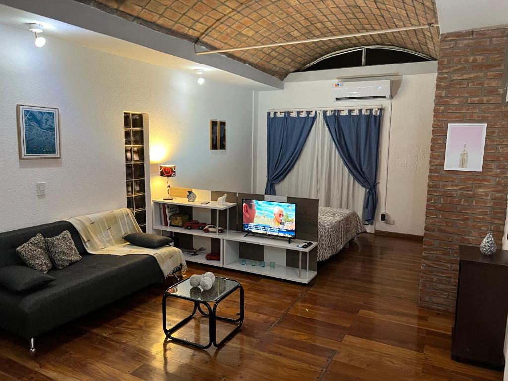 sala de estar con sofá y TV en Departamento tipo Loft en Balvanera en Buenos Aires