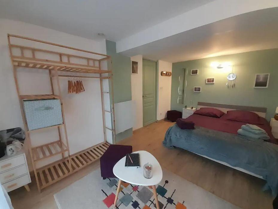 Un dormitorio con una cama y una mesa. en Calme et simplicité, en Chelles