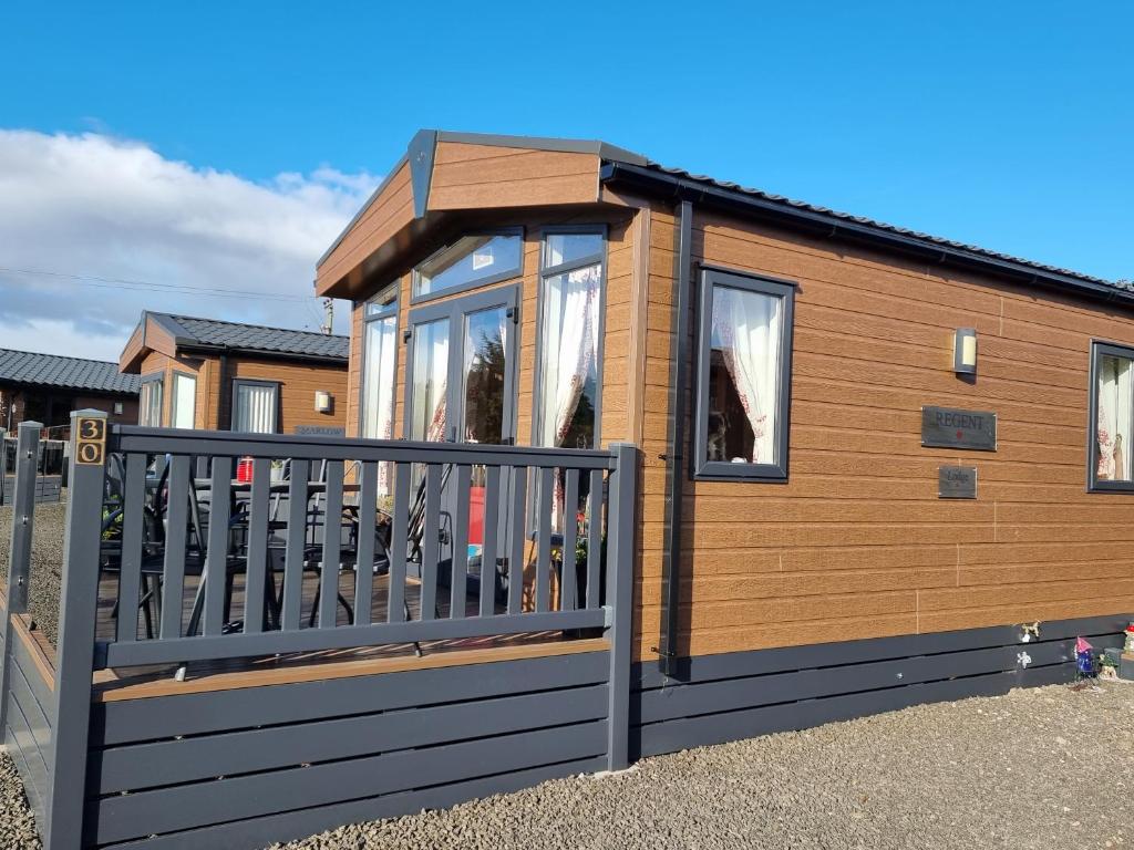 a tiny house with a gate in front of it at Kimadalyn in Forfar