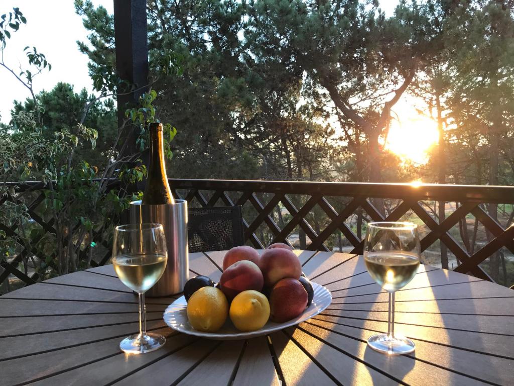 een schaal fruit op een tafel met wijnglazen bij Excellent T2 apartment with pools 400m Falesia beach in Albufeira
