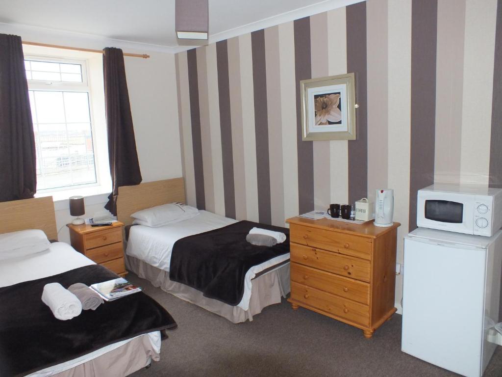 A bed or beds in a room at Marina Inn 