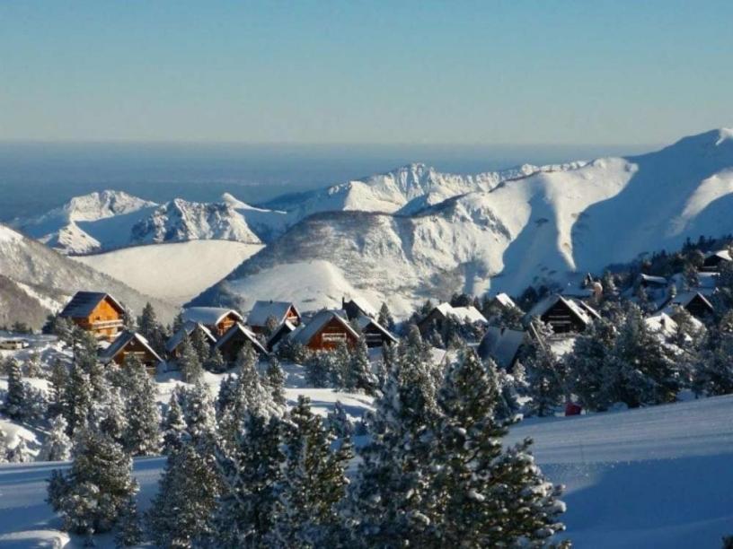 a snow covered mountain range with houses and trees at GITE LES 3 EDELWEISS - Maison SEGUITTE - 6 PERSONNES in Arette