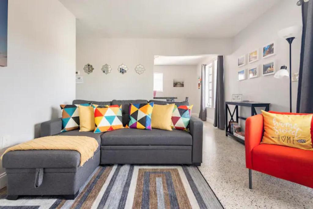 Sleeps 8, Havana Nights in Miami في ميامي: غرفة معيشة مع أريكة وكرسي احمر