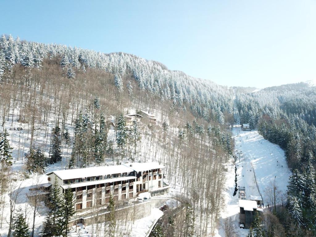 a building on the side of a snow covered mountain at Residenza Riva Wellness Apartment Spa in Abetone