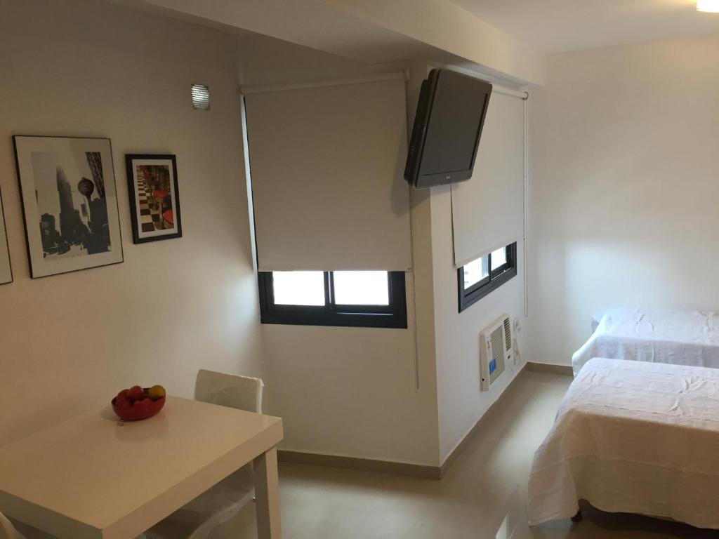 1 dormitorio con 1 cama y TV en la pared en Estudio San Lorenzo en San Miguel de Tucumán