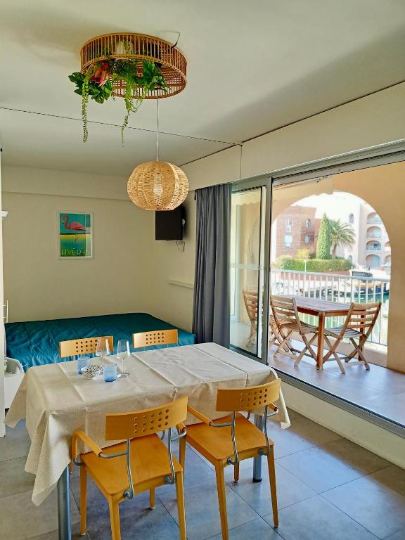 une salle à manger avec une table et des chaises et un balcon dans l'établissement Studio Hyeres Port, à Hyères