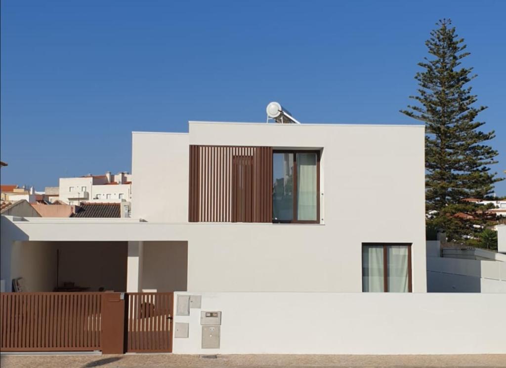 Una casa blanca con un árbol delante. en Villa Algarve, en Alcantarilha