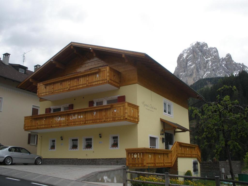 a building with wooden balconies on the side of it at Garni Ossi in Santa Cristina in Val Gardena