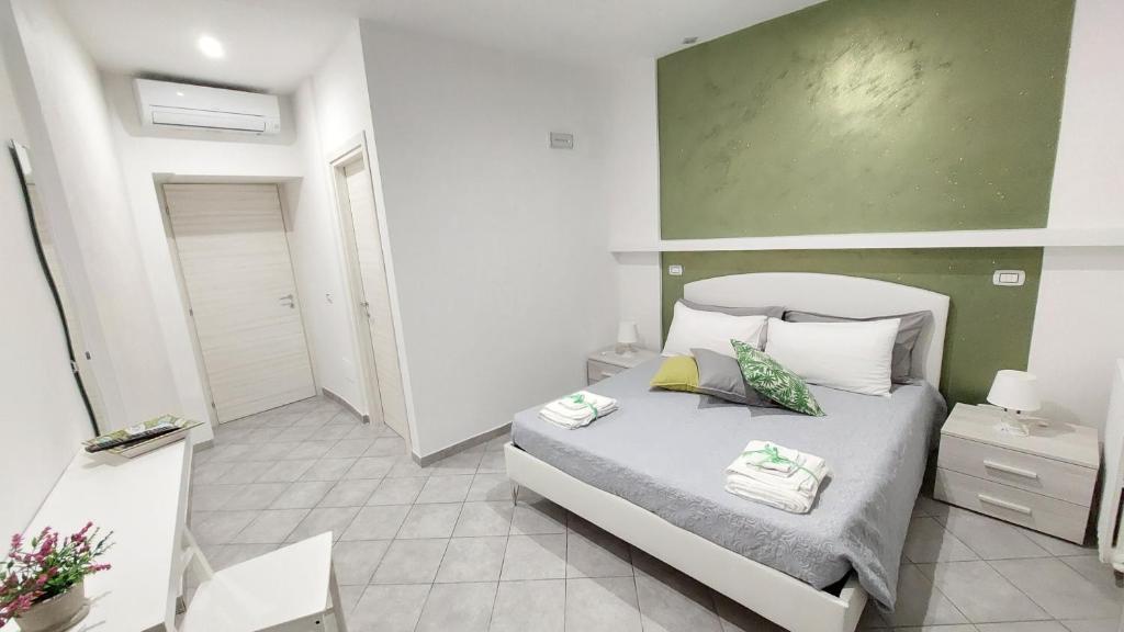 een slaapkamer met een bed en een groene muur bij B&B Marina in Vietri