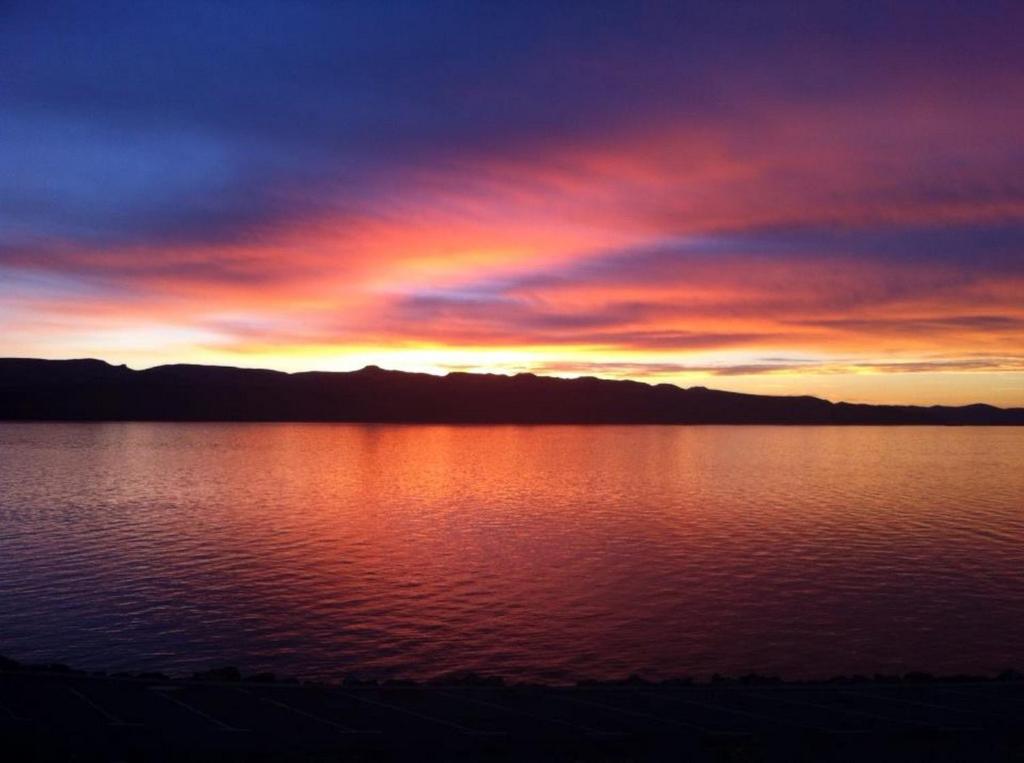 um pôr-do-sol sobre uma grande massa de água em Delfin Apartments em Sveti Juraj