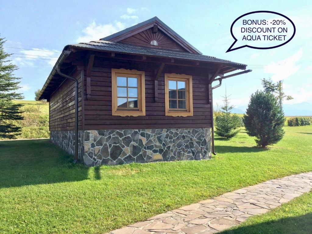 a small cabin on a grassy field at Chata 107 Tatralandia Village in Liptovský Mikuláš