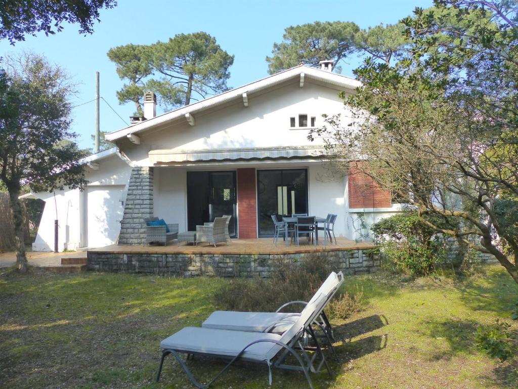 ein weißes Haus mit einer Bank davor in der Unterkunft Villa ONGUI ETHORRI Villa pour 6 ou 8 personnes Wifi gratuit in Soorts-Hossegor