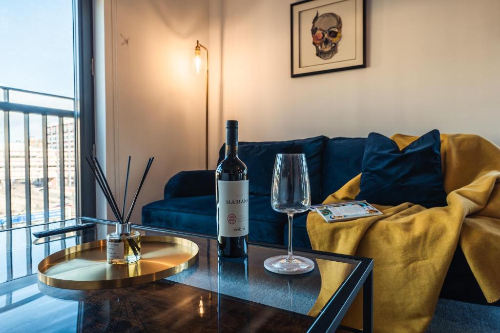 a living room with a bottle of wine on a table at City View - A Stunning 2 Bed Apartment in Glasgow
