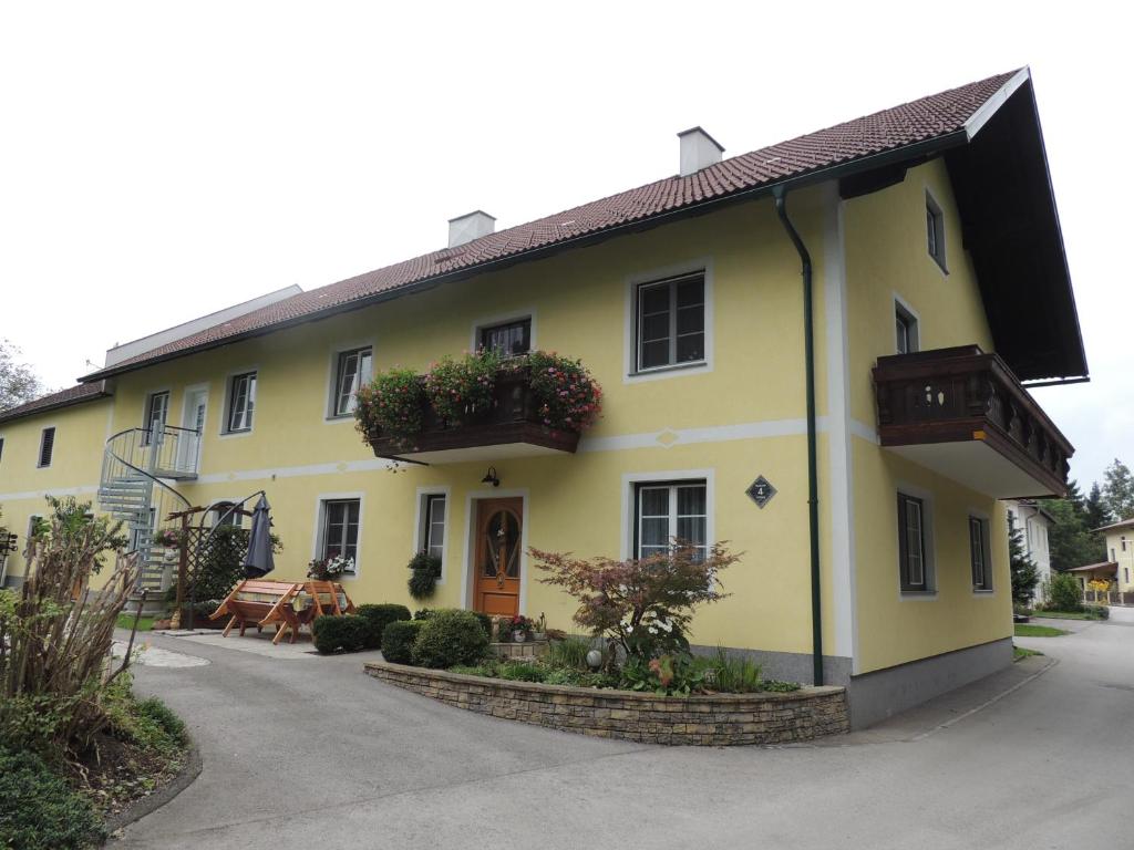 Una casa amarilla con un balcón en el lateral. en Ferienwohnung Heimberger, en Purgstall
