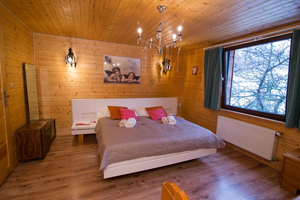 伊斯泰布納的住宿－Gościniec Tokarzonka，木制客房内的一间卧室,配有一张床