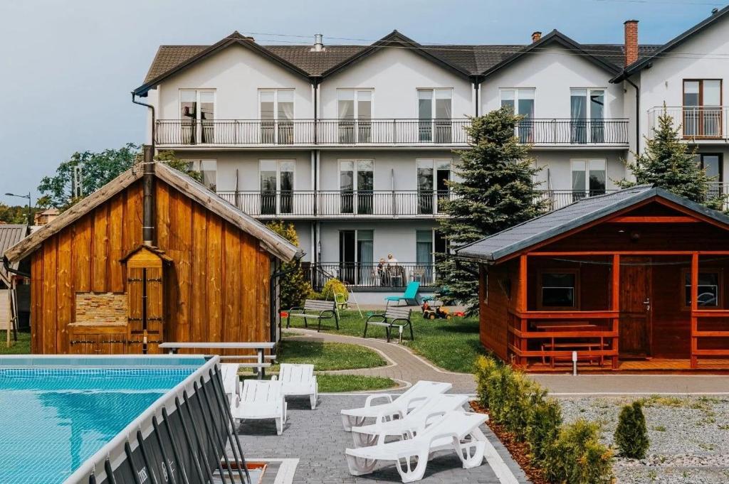 a resort with a pool and a large building at Willa Alexandria - Domki, Apartamenty, Pokoje z Basenem in Karwia