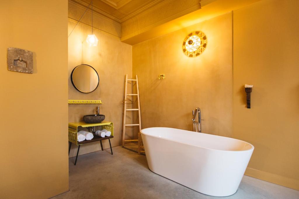 a bathroom with a large white tub in a room at Boutiquehotel The Church in Arnhem