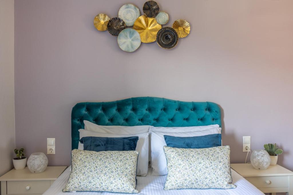 a bed with a blue headboard and two pillows at Anna Studio in Amoudara Herakliou