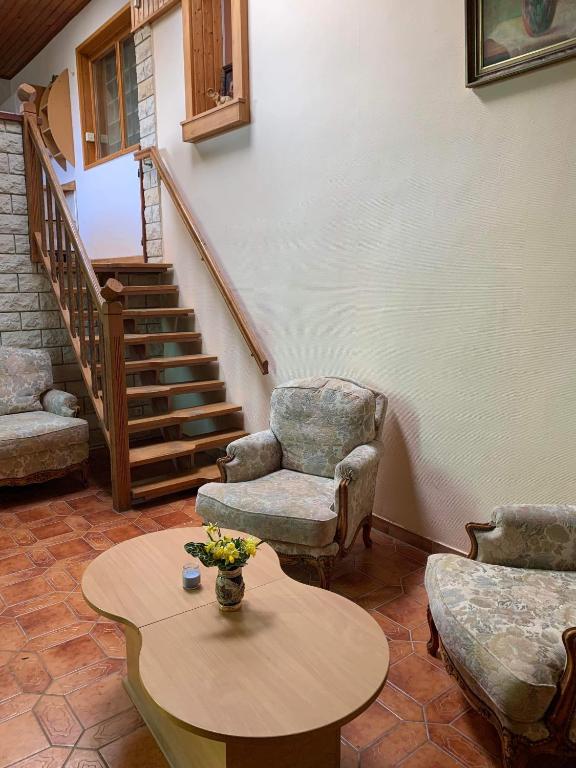 - un salon avec des chaises, une table et des escaliers dans l'établissement Maison de vacances, à Frotey-lès-Vesoul