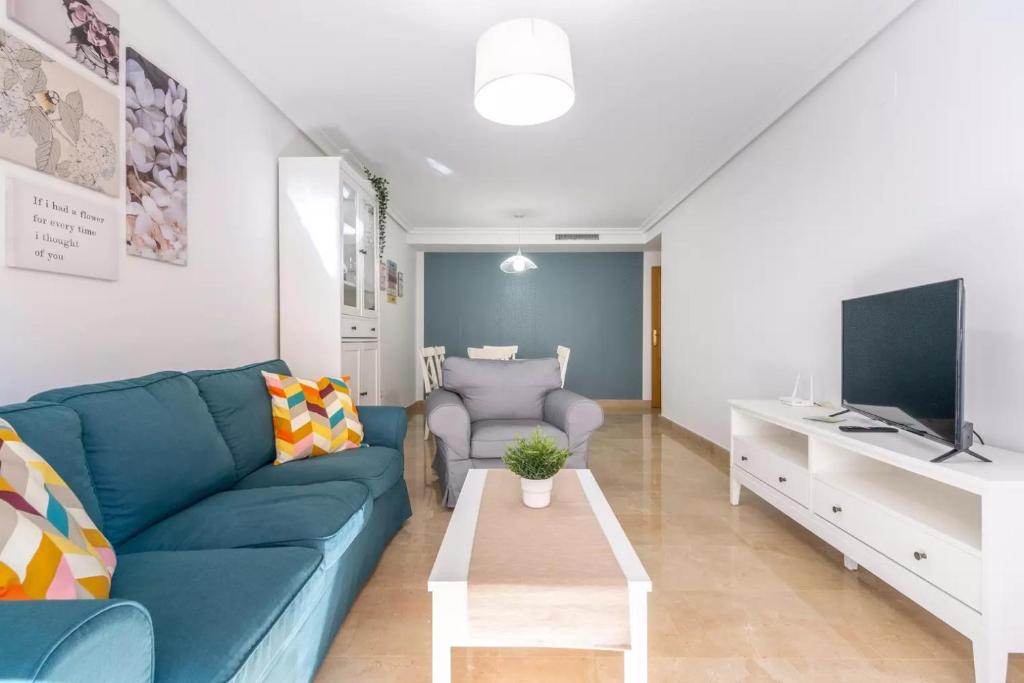 a living room with a blue couch and a tv at 090 Apartamento Imperial in Torrevieja
