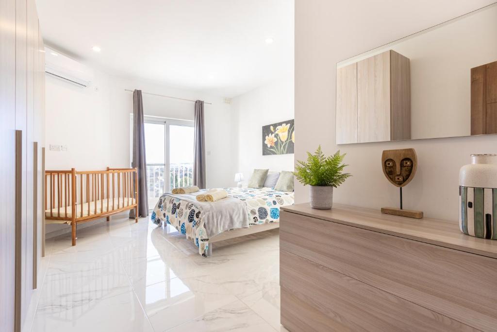 a white bedroom with a bed and a balcony at H3 - Modern and Spacious 3 Bedroom Apartment in San Ġwann
