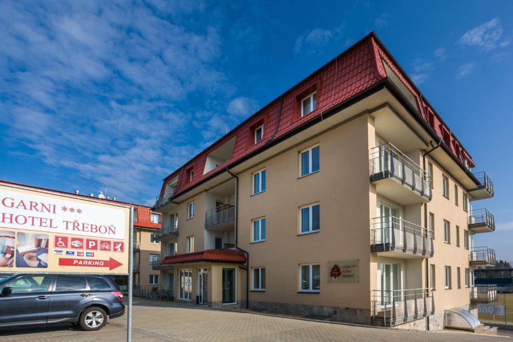 ein Gebäude mit einem davor geparkt in der Unterkunft Garni Hotel Třeboň in Třeboň
