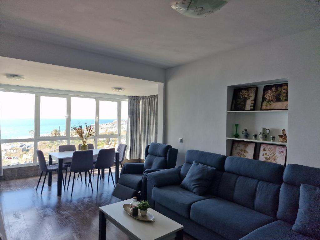 een woonkamer met een blauwe bank en een tafel met stoelen bij La Teresita in Torrox Costa