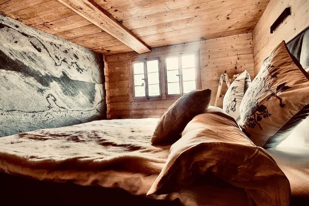 duże łóżko w pokoju z oknem w obiekcie Luxury & Cosy 3.5 rooms apartment in almost 300 years old Chalet w mieście Leukerbad