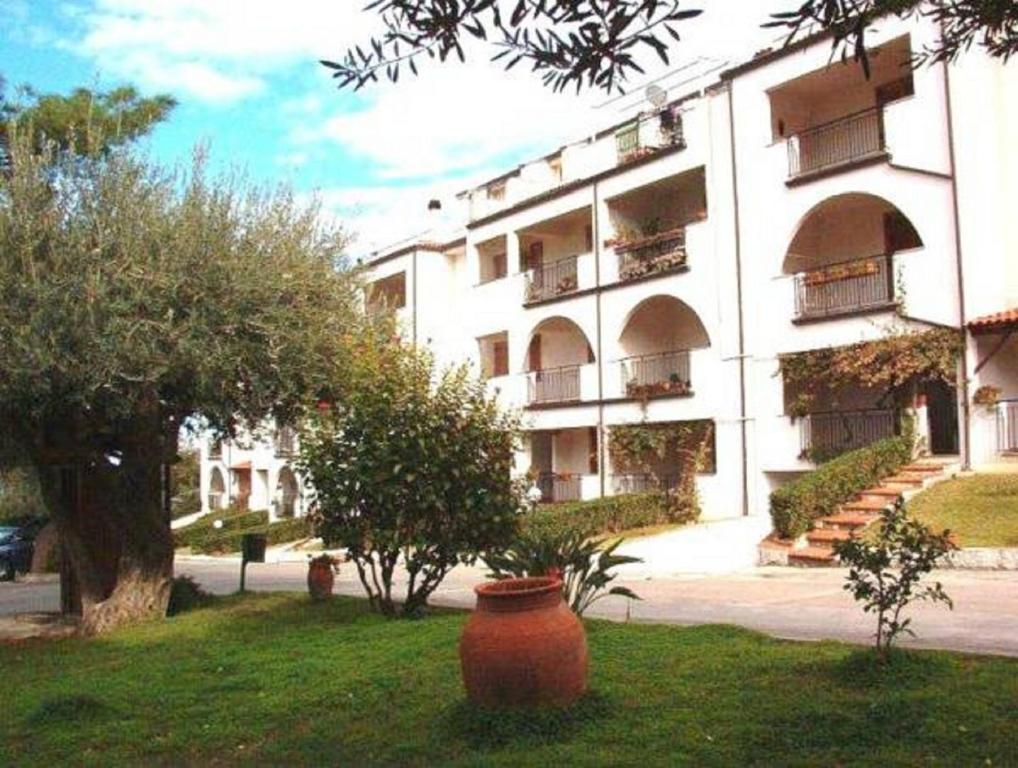 a large building with a large vase in the grass at Residence L'uliveto in Gioiosa Marea