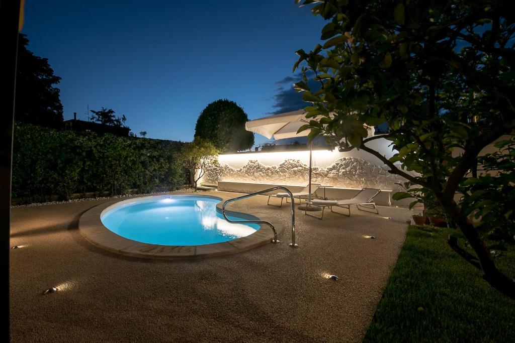 a swimming pool in a yard at night at VILLA IARA in Cerveteri