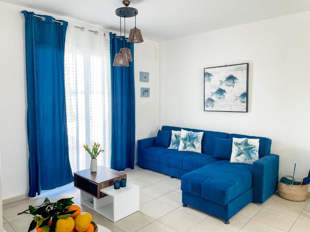 a blue couch in a living room with blue curtains at Blue Lagoon Latsi Centre in Lachi