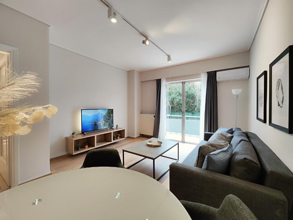 uma sala de estar com um sofá e uma televisão em Etolou A2 - by Verde Apartments em Atenas