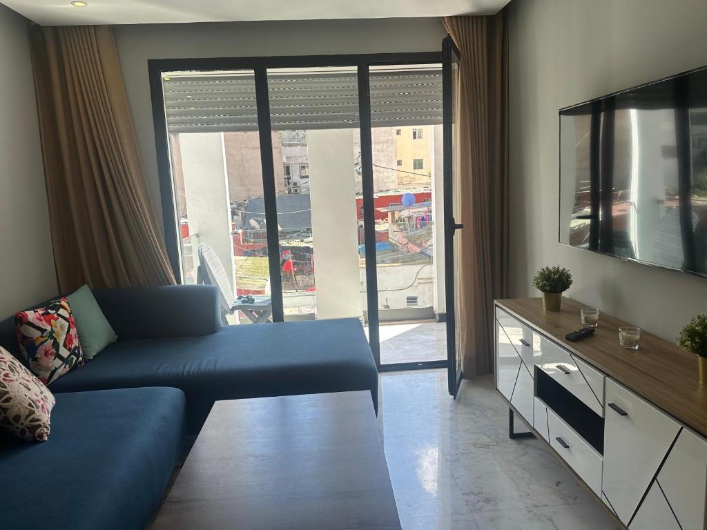a living room with a blue couch and a tv at Twin Center Oasis - Luxury Apartment with Free Parking in Casablanca