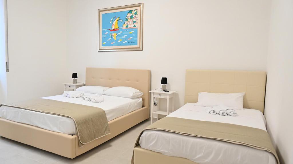 dos camas sentadas una al lado de la otra en un dormitorio en La Veranda Beach, en Agropoli