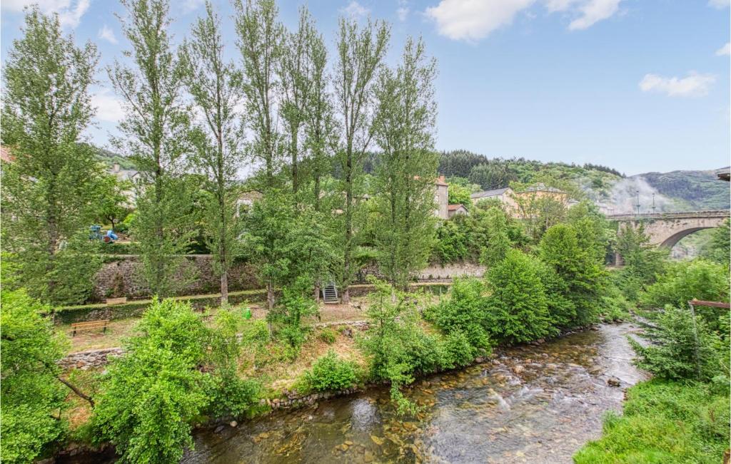 a river with trees and a bridge in the background at Cozy Apartment In Saint Jean Du Bruel With Private Swimming Pool, Can Be Inside Or Outside in Saint-Jean-du-Bruel