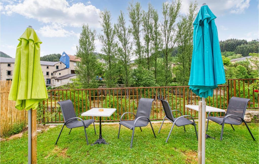 a group of chairs and tables with umbrellas at Cozy Apartment In Saint Jean Du Bruel With Private Swimming Pool, Can Be Inside Or Outside in Saint-Jean-du-Bruel
