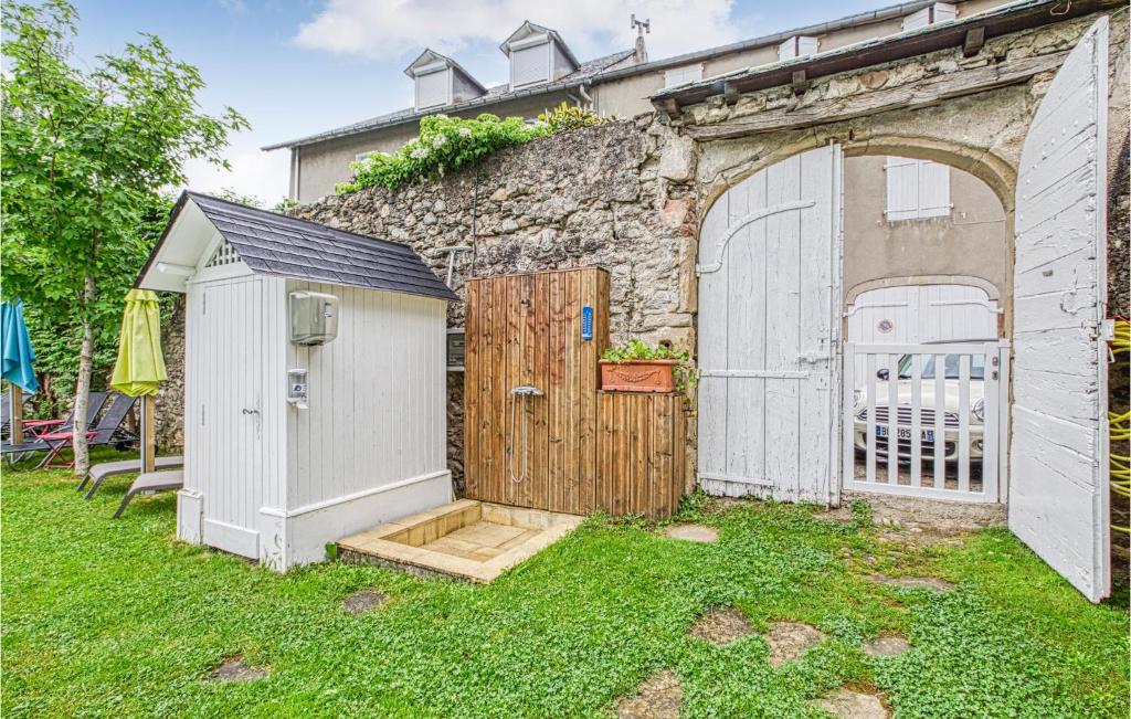 a building with a gate and a wooden door at Cozy Apartment In Saint Jean Du Bruel With Private Swimming Pool, Can Be Inside Or Outside in Saint-Jean-du-Bruel