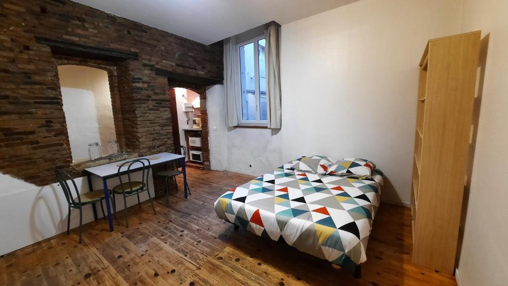 een slaapkamer met een bed, een tafel en een raam bij PROMO 20-27 mai Toulouse 15 mn app refait à neuf RDC 2 personnes Lit 140 in Montastruc-la-Conseillère