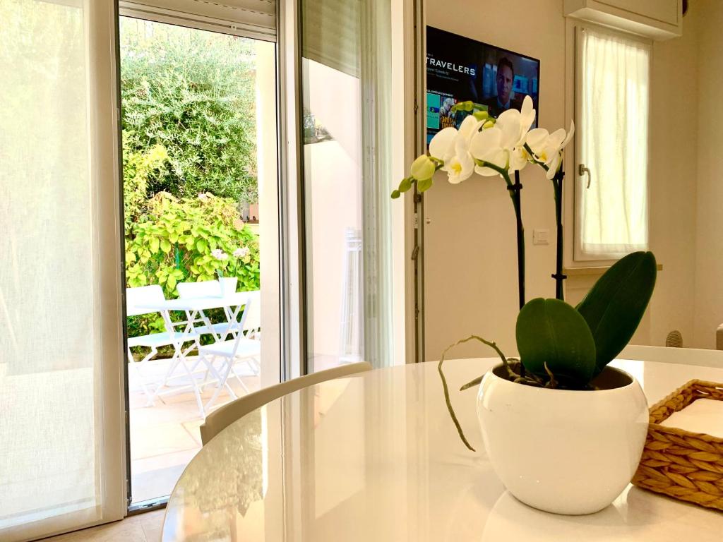 a glass table with a vase with a plant on it at Suite Claudia in Sirmione
