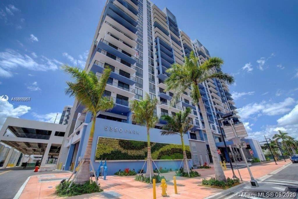 um edifício alto com palmeiras em frente em APARTMENT FOR RENT 2 BED 2 BATH 1 Parking DOWNTOWN DORAL em Miami