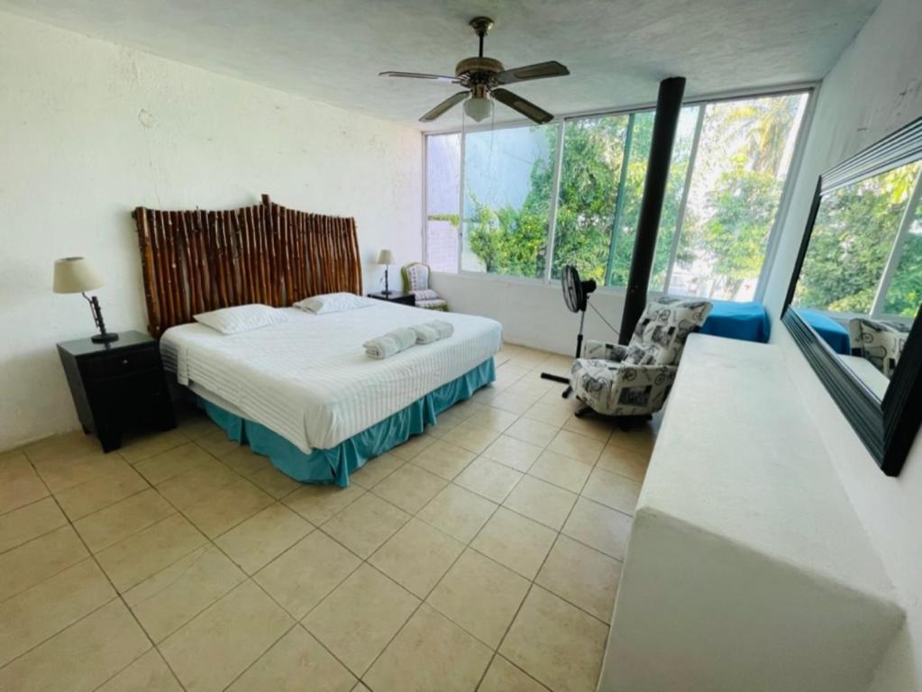 Schlafzimmer mit einem Bett und einem Deckenventilator in der Unterkunft Casa Alfenapa completa para ti y tu familia, pet friendly y a pie del lago in Tequesquitengo