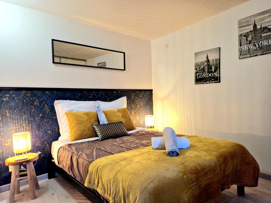um quarto com uma cama e um espelho na parede em Havre de Paix - Maisonnette Charmante avec Extérieur Privé em Blois