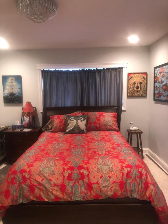 una camera da letto con un grande letto con un piumone rosso di Raven's Cache Bed and Breakfast a Ganges
