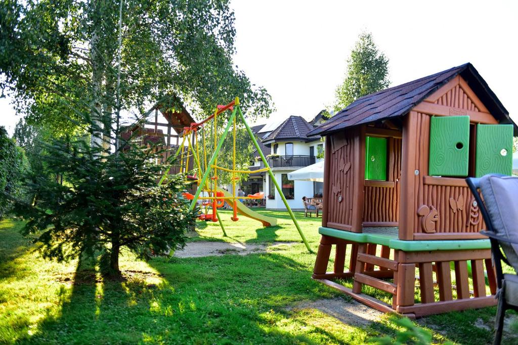 a playground with a small house and a slide at Natura Family Resort in Avrig