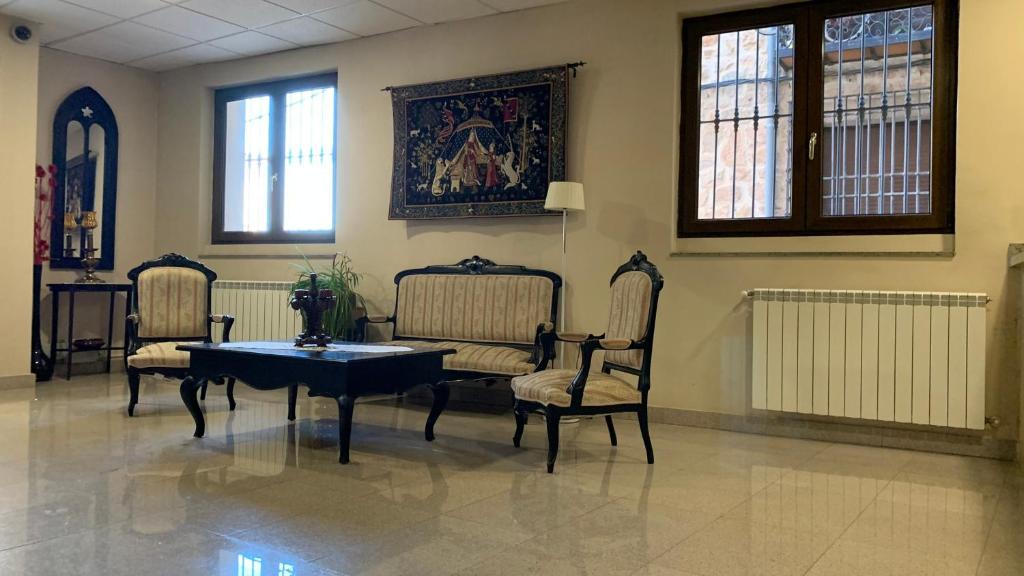 a room with chairs and a table and a painting on the wall at Hotel Posta Real in Sigüenza