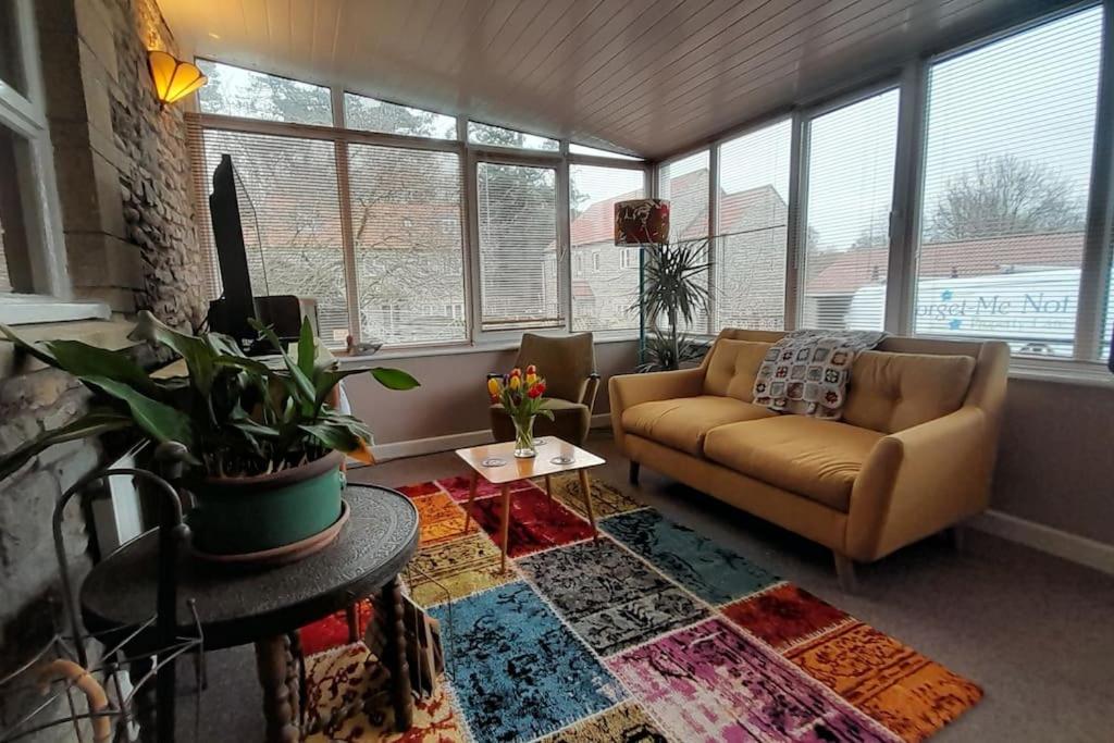 a living room with a couch and a table at Quirky mid century themed holiday home in Shepton Mallet
