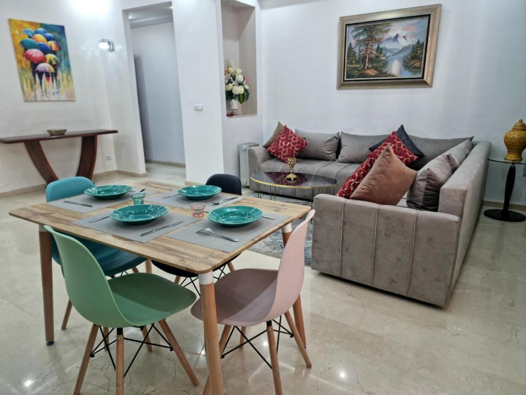 a living room with a table and chairs and a couch at Luxury Family House with Garden View Casablanca in Casablanca