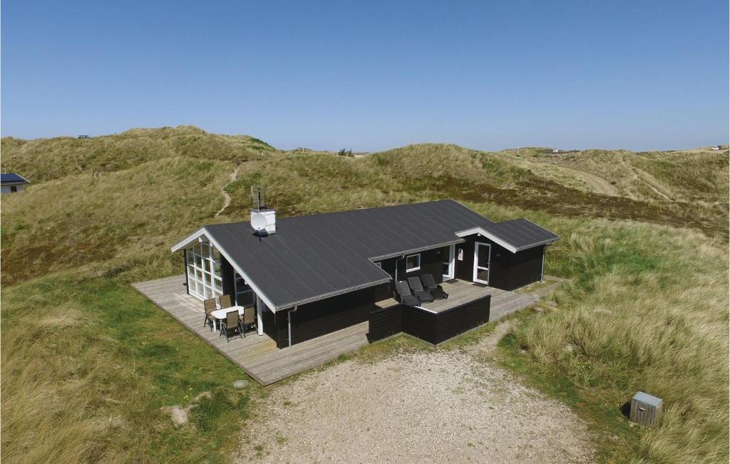 a black house on top of a hill at Pet Friendly Home In Hvide Sande With Wifi in Havrvig